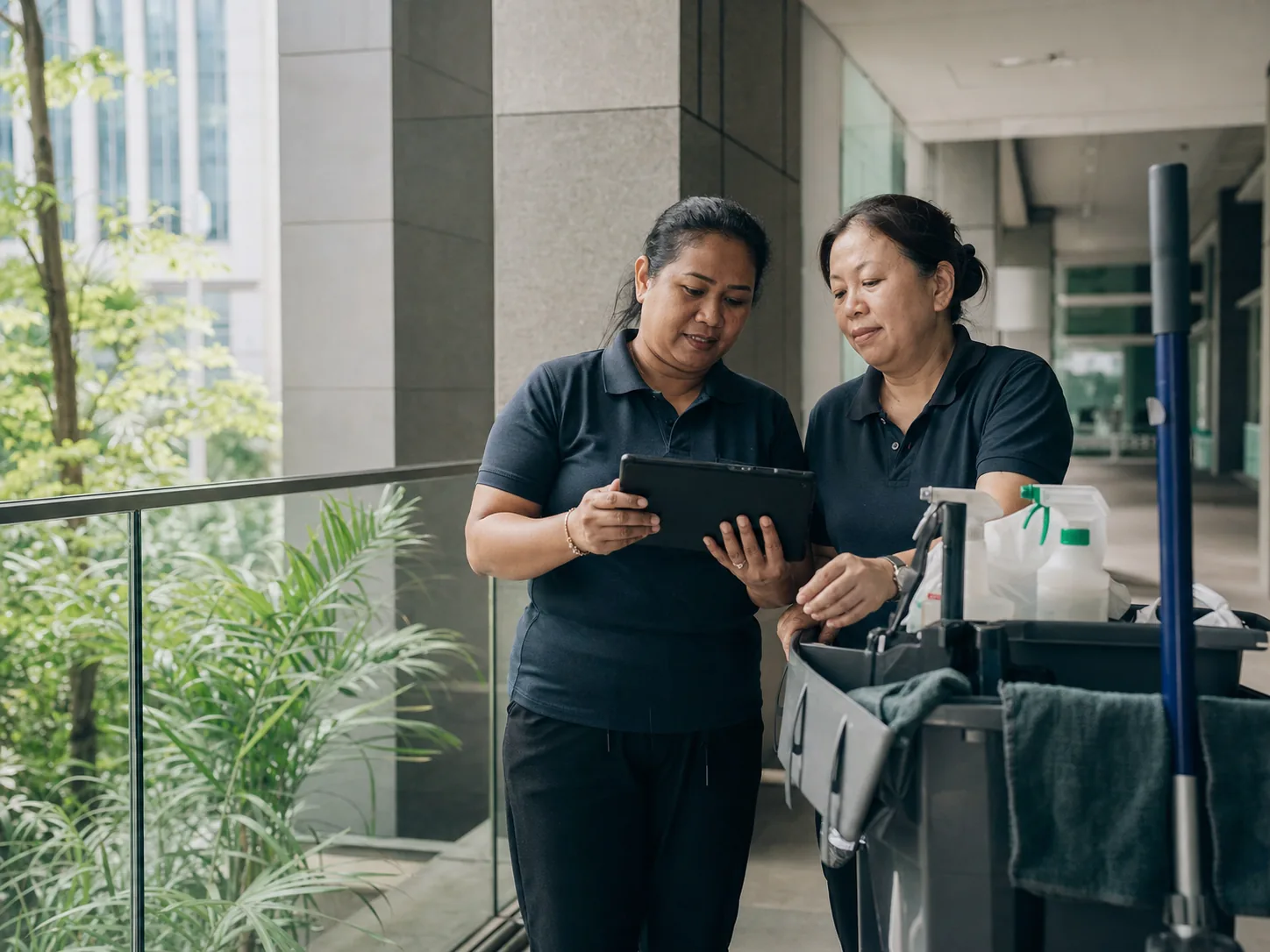 Commercial cleaning supervisors reviewing site work on a tablet